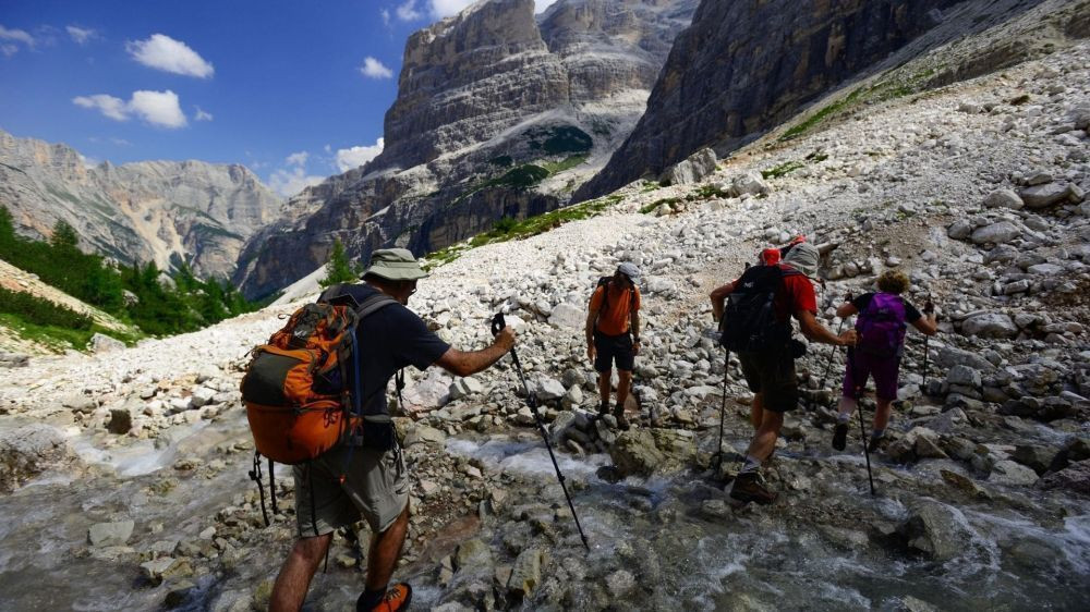 Randonneurs traversant un torrent de montagne - Dolomites - Italie
